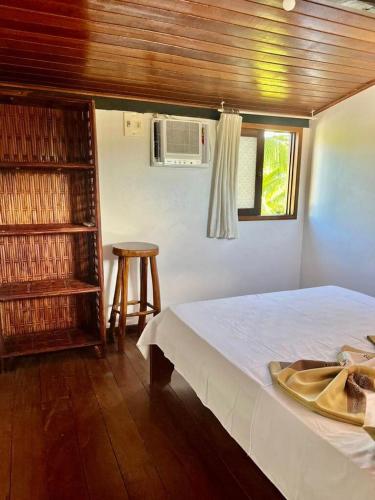 a bedroom with a bed and a window and a table at Apto pé na areia de Gamboa do Morro in Cairu