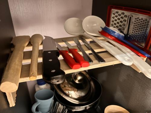 a bunch of utensils on a wooden shelf at Mimah's cozy getaway near JKIA at Taurus Residences in Nairobi
