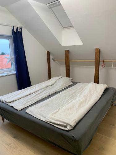 a large bed in a room with a window at The Hidden Sea View in Sønderborg
