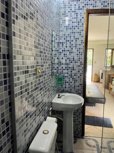 a bathroom with a white sink and a toilet at Apto pé na areia de Gamboa do Morro in Cairu