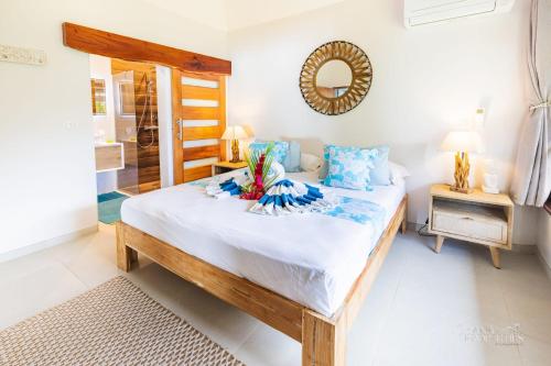 a bedroom with a large bed with a mirror on the wall at Villa Vanaki - Beachfront Villa 4BR w AC in Moorea