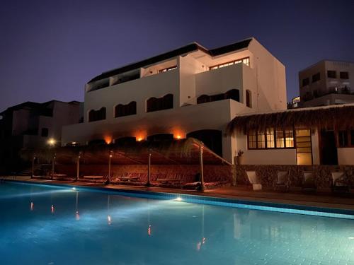 a swimming pool in front of a building at night at Serenity Lodge in Sharm El Sheikh