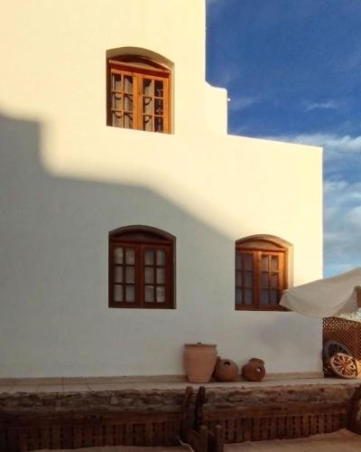 a white building with windows and vases on a ledge at Serenity Lodge in Sharm El Sheikh