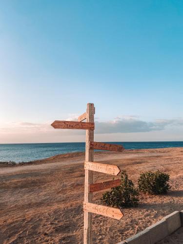 a wooden sign on the beach near the ocean at Serenity Lodge in Sharm El Sheikh
