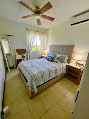 a bedroom with a bed and a ceiling fan at Bohemian Townhouse Palm Beach Aruba in Palm-Eagle Beach