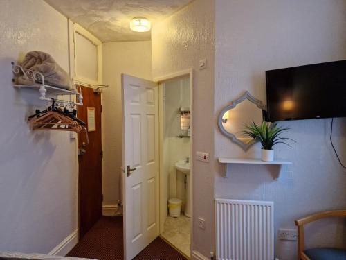 a room with a bathroom with a toilet and a mirror at Stafford House in Blackpool