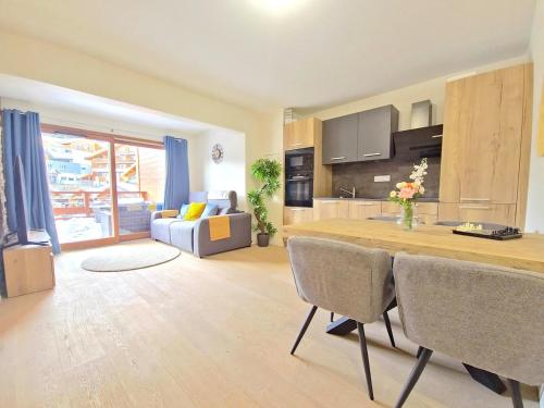 une cuisine et un salon avec une table et des chaises dans l'établissement New - Spacious - Private garage, à L'Alpe-d'Huez