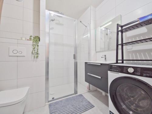 une salle de bain avec douche et machine à laver dans l'établissement New - Spacious - Private garage, à L'Alpe-d'Huez