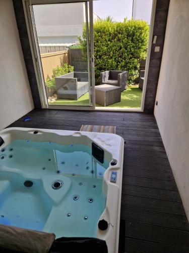 une baignoire jacuzzi dans une chambre avec fenêtre dans l'établissement Heated pool, indoor spa, 5bedroom, 10pl, near Cap d'Agde, Mediterranean, à Agde