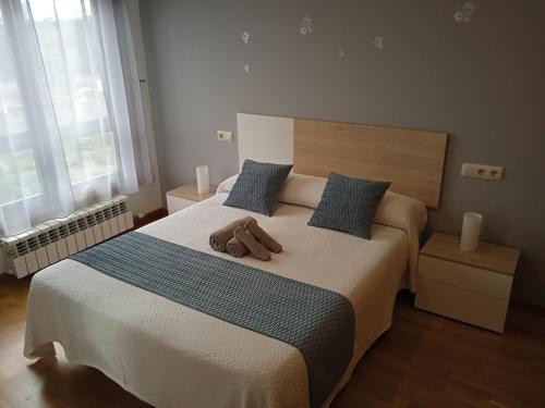 een slaapkamer met een bed met twee bruine schoenen erop bij Apartamento Rimiño in Salvatierra de Miño