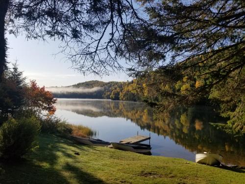 a view of a lake with two boats on the shore at Kan-à-Mouche Pourvoirie Auberge et Chalets in Saint-Michel-des-Saints