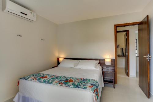 a bedroom with a bed and a hallway with a mirror at Hotel Sete Ilhas in Florianópolis