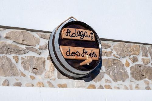 a clock on a stone wall with writing on it at Adega dos Avós - Casa completa in Alcobaça