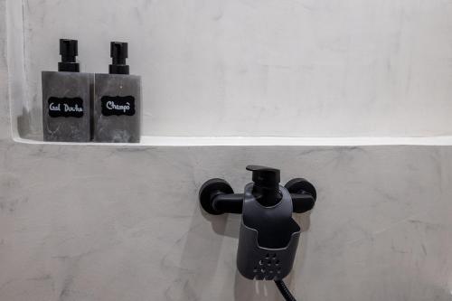 a bathroom with two soap dispensers on a wall at Adega dos Avós - Casa completa in Alcobaça