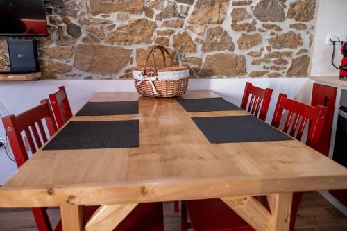 a wooden table with chairs and a basket on top at Adega dos Avós - Casa completa in Alcobaça