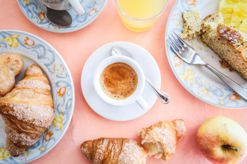 una mesa con platos de comida y una taza de café en Hotel Principe, en Caorle