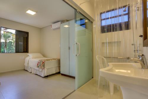 a bathroom with a sink and a bed in a room at Hotel Sete Ilhas in Florianópolis