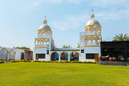 a mosque with two towers and a grass field at Macacona Hacienda Hotel in Ica