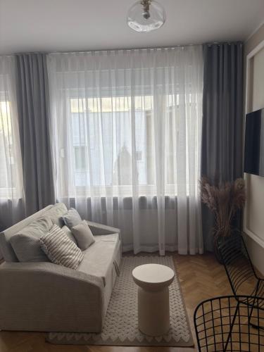 a living room with a couch and a large window at Willa Jelitkowska in Gdańsk
