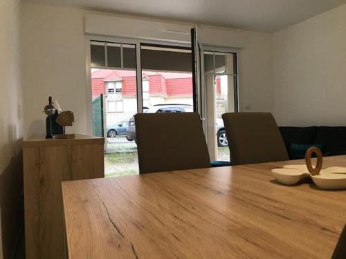 une salle à manger avec une table et des chaises en bois dans l'établissement ApptT2 neuf Port de Saint Valéry sur Somme, à Pinchefalise