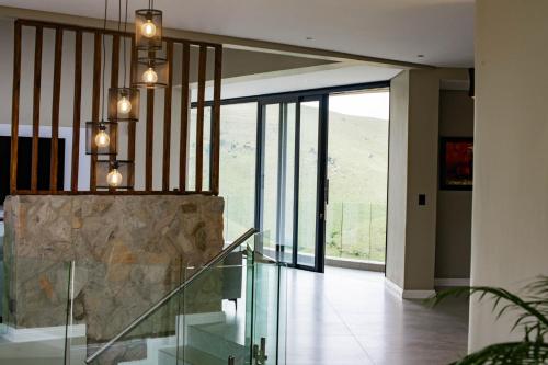 a lobby with a glass staircase and a large window at The Curve in Dullstroom