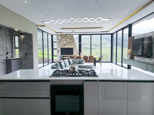 a kitchen with a stove and a living room at The Curve in Dullstroom