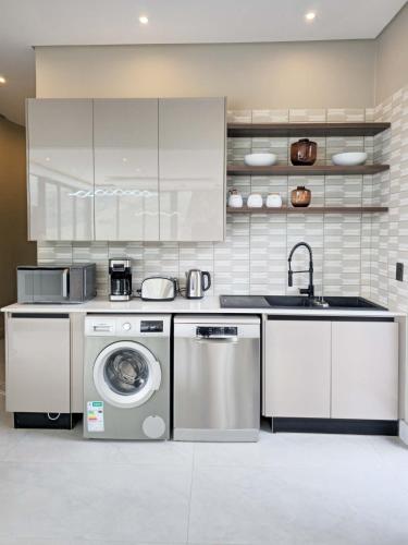 a kitchen with a washing machine and a sink at The Curve in Dullstroom