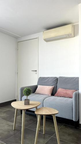 un salon avec un canapé bleu et une table dans l'établissement Duplex - Beach 15min walk, à Saint-Raphaël