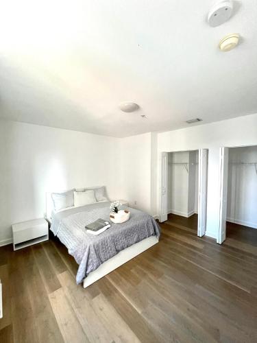 a white bedroom with a bed and a wooden floor at Private bedroom in Miami - Coral Gables 601 in Miami