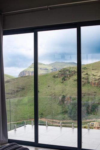 a window with a view of a mountain view at The Curve in Dullstroom
