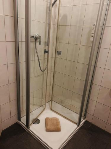 La salle de bains est pourvue d'une douche et d'un siège en bois. dans l'établissement Pension Osthoff, à Wülfrath