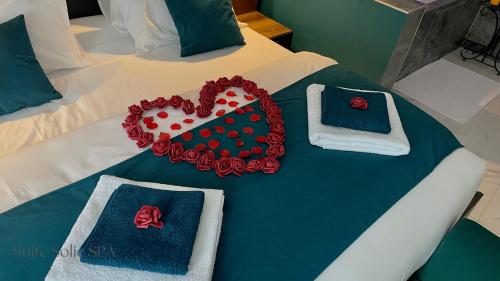 a bed with a heart made out of towels at SUITE SOLIE SPA Wintzenheim in Wintzenheim