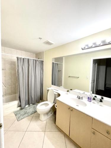 a bathroom with a toilet and a sink and a mirror at Private bedroom in Miami - Coral Gables 601 in Miami
