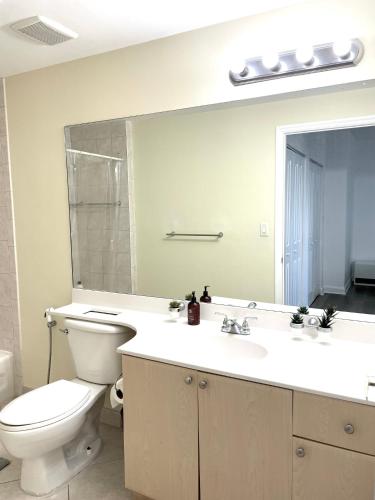 a bathroom with a toilet and a sink and a mirror at Private bedroom in Miami - Coral Gables 601 in Miami