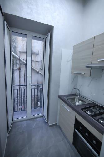 a small kitchen with a sink and a window at Terrazza 19 in Naples