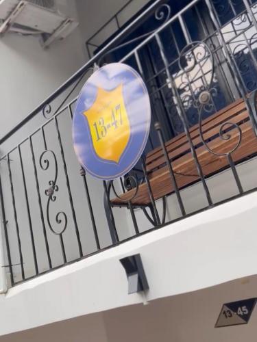 a blue and yellow sign on a railing next to a bench at Confort 13-47 in Cali