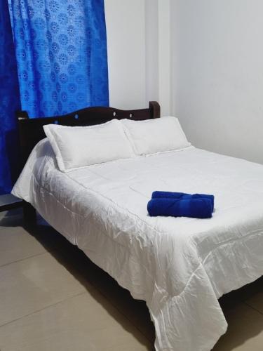 a bed with a blue pillow on top of it at Confort 13-47 in Cali