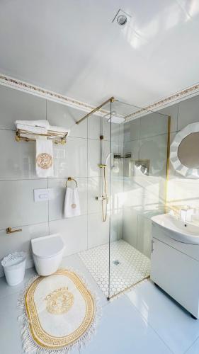 a bathroom with a shower and a toilet and a sink at Fela in Versace House in Gqeberha