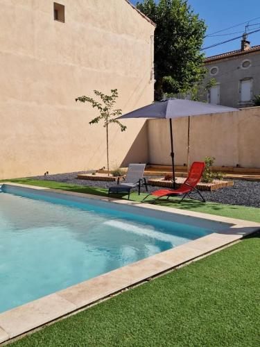 a swimming pool with two chairs and an umbrella at Charming Master House with Private Pool in Quarante