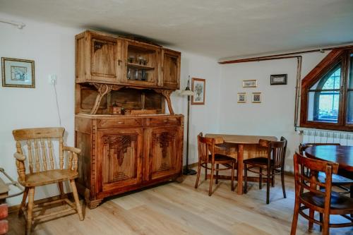 a dining room with a wooden cabinet and a table at Cisówka Pokoje Gościnne in Piwniczna