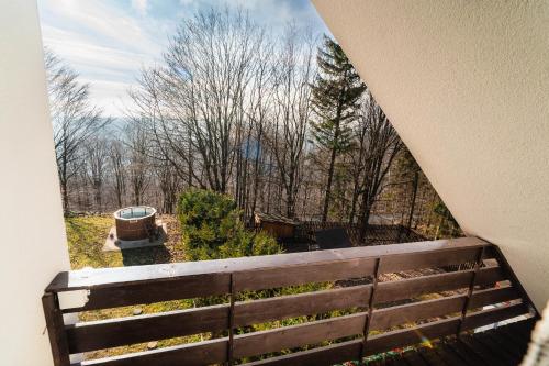 a balcony with a view of trees and a bench at Molnárkalács vendégház in Mátraszentimre