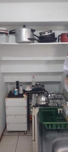 a kitchen with a stove and some pots and pans at Qto privativo em Duplex a 5km do carnaval in Olinda