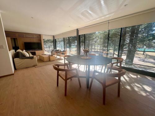 a large living room with a table and chairs at Casa entre pinos in La Florida