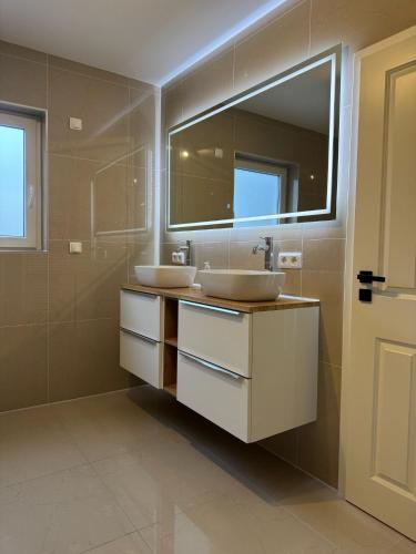 a bathroom with two sinks and a mirror at Ferienunterkunft Lutherbaum 4 Zimmer 6 Betten in Worms