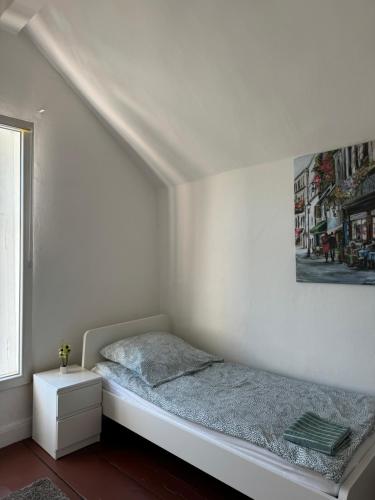 a white bedroom with a bed and a window at Monteurshaus in Münsternähe in Greven