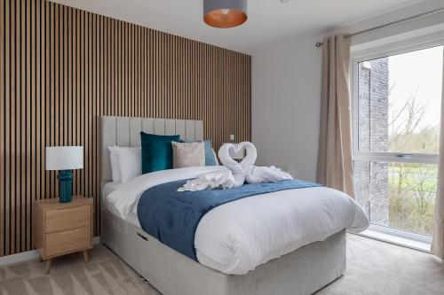 a bedroom with a large bed with swans on it at 31 Grand Court - Lovely Home Near Canal, Park, & Central MK in Milton Keynes