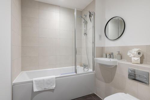 a bathroom with a tub and a toilet and a sink at 31 Grand Court - Lovely Home Near Canal, Park, & Central MK in Milton Keynes