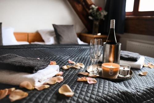 a bed with a bottle of wine and a glass at Wellness hotel & minipivovar Kněžínek in České Budějovice