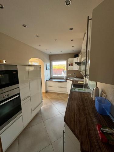 a kitchen with white cabinets and a large window at Tolle Wohnung in Taunusstein in Taunusstein
