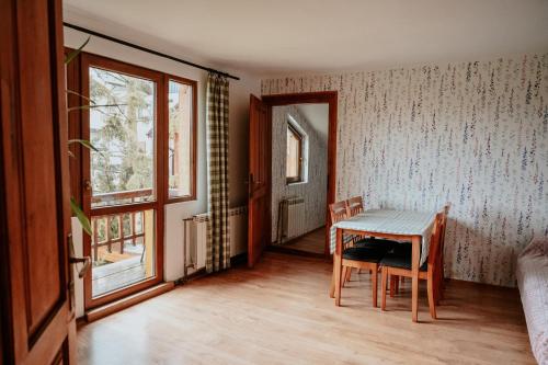 a room with a table and chairs and a window at Cisówka Pokoje Gościnne in Piwniczna